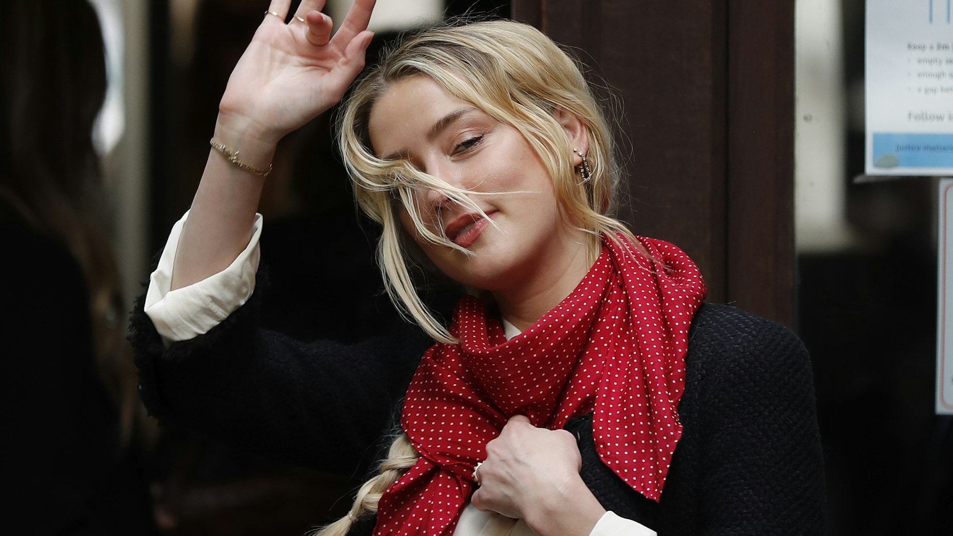 Amber Heard winkt vor dem Gerichtsgebäude.