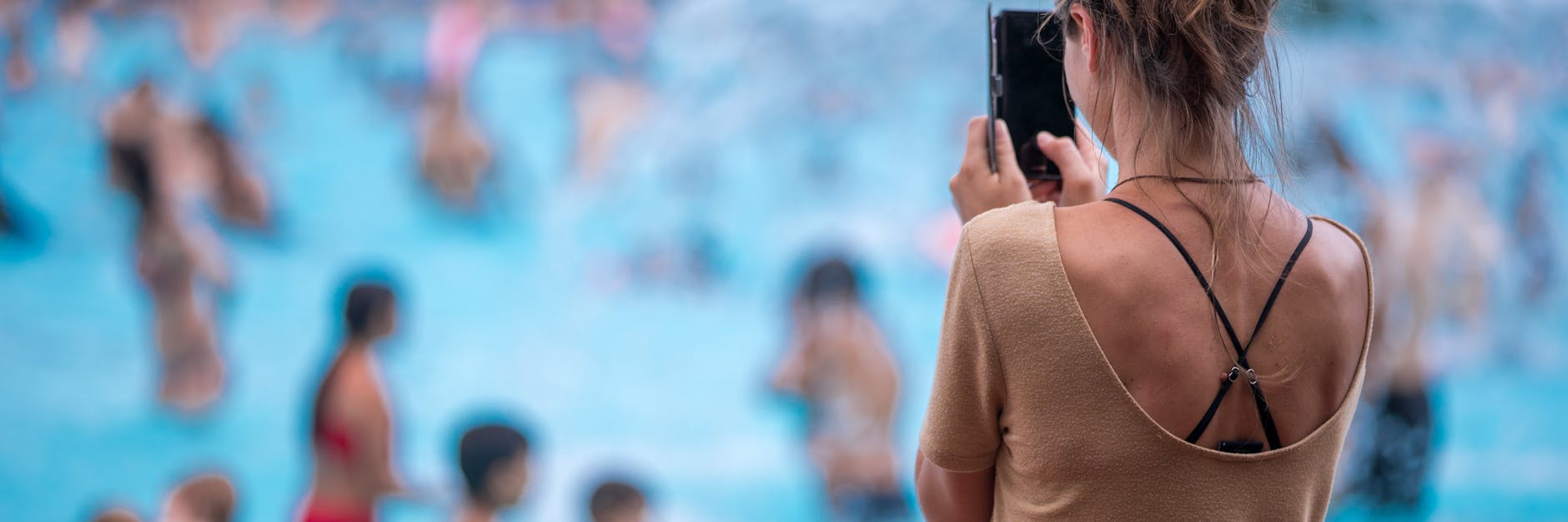 Eine junge Frau fotografiert mit ihrem Handy im Prinzenbad (Symbolbild).