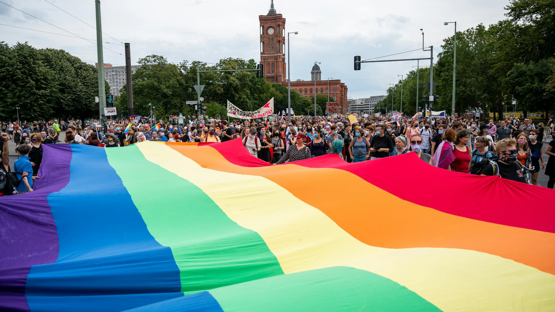 Teilnehmer beim Dyke Marsch mit einer großen Regenbogenflagge (25.7.2020).