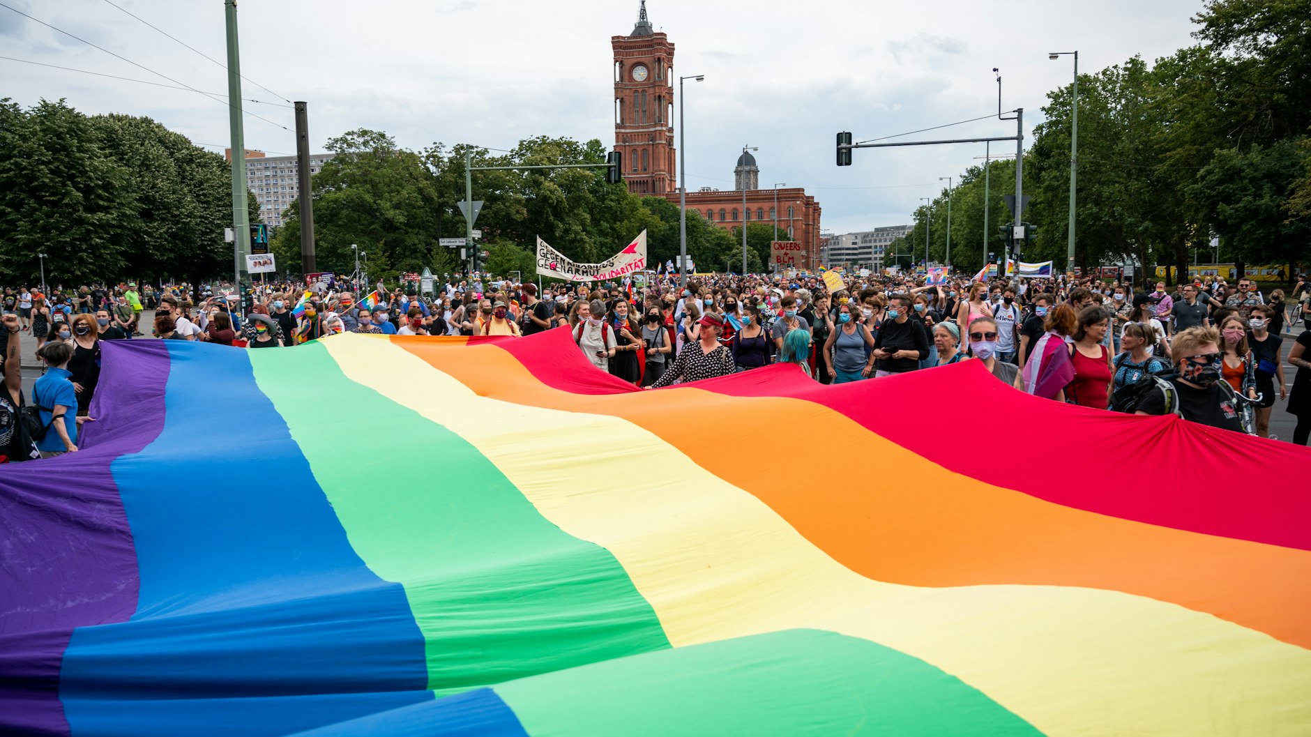 Teilnehmer beim Dyke Marsch mit einer großen Regenbogenflagge (25.7.2020).