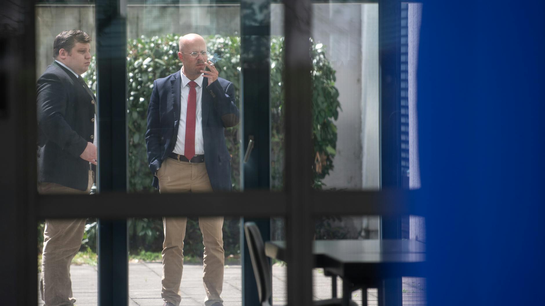 Andreas Kalbitz (r), AfD-Fraktionschef im Brandenburger Landtag, raucht während einer mündlichen Verhandlung des AfD-Bundesschiedsgerichts zur Frage, ob er rechtmäßig Mitglied der Partei ist oder nicht. 