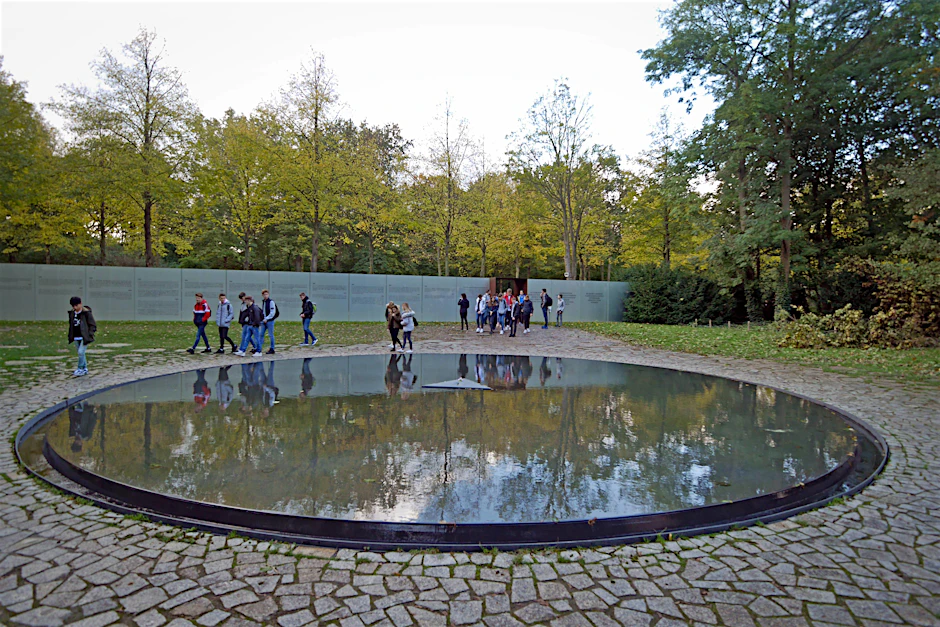 Ein kreisrundes&nbsp; Wasserbecken, der "Brunnen", ist zentraler Teil des von Dani Karavan geschaffenen Denkmals. Die Kreisform symbolisiere Gleichheit, das Wasser vergossene Träne.&nbsp;&nbsp;