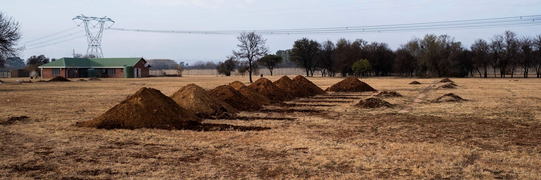 Frisch ausgehobene Gräber auf dem Honingnestkrans-Friedhof am Rande Pretorias.