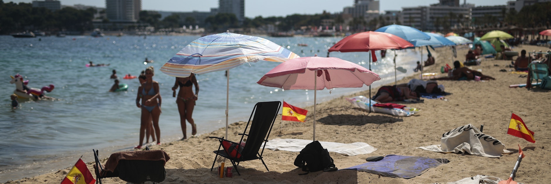 Spanische Miniatur-Flaggen, die an einem Strand auf Mallorca in den Boden gesteckt sind, sollen den Mindestabstand markieren. 