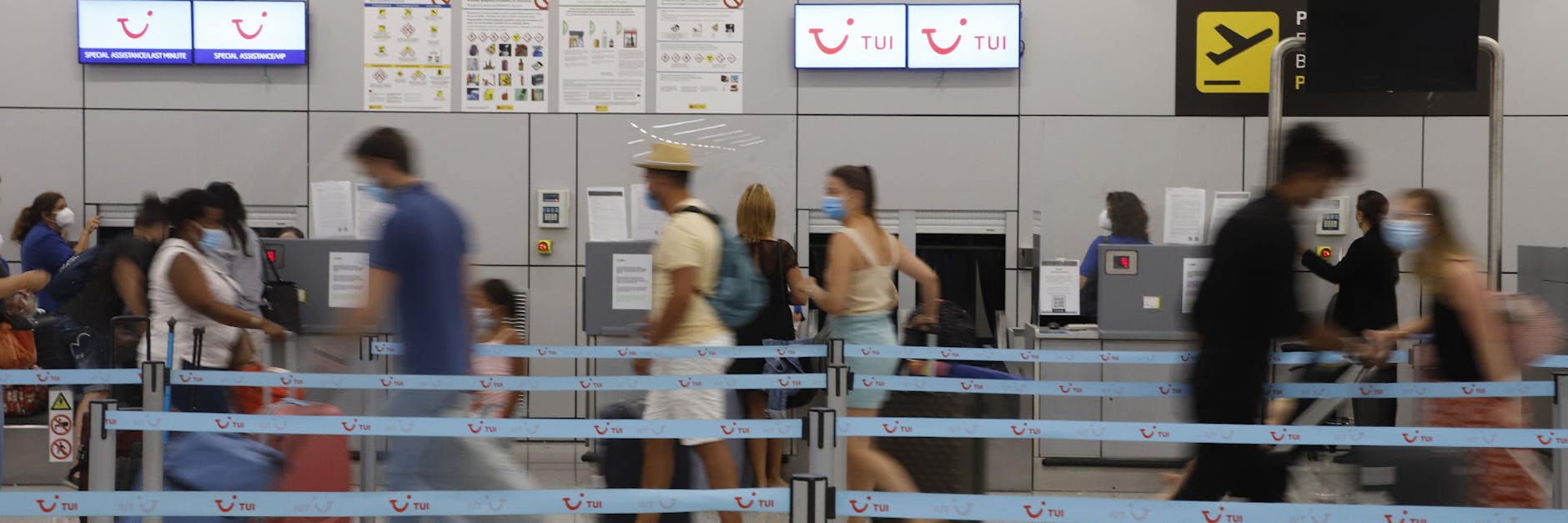 Am Flughafen von Palma auf Mallorca wollen Passagiere an einem Tui-Schalter einchecken.