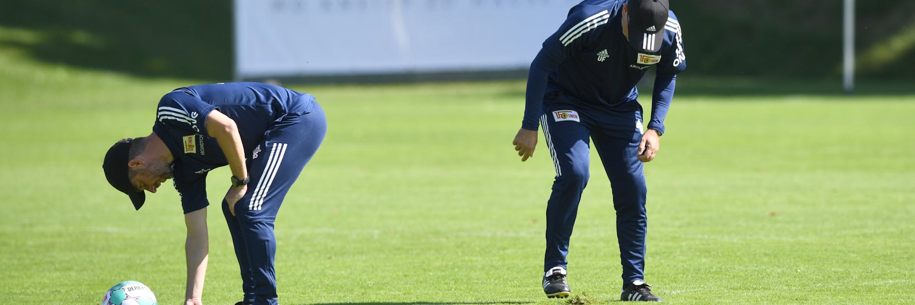 Sebastian Bönig und Urs Fischer bearbeiten den schlechten Rasen.