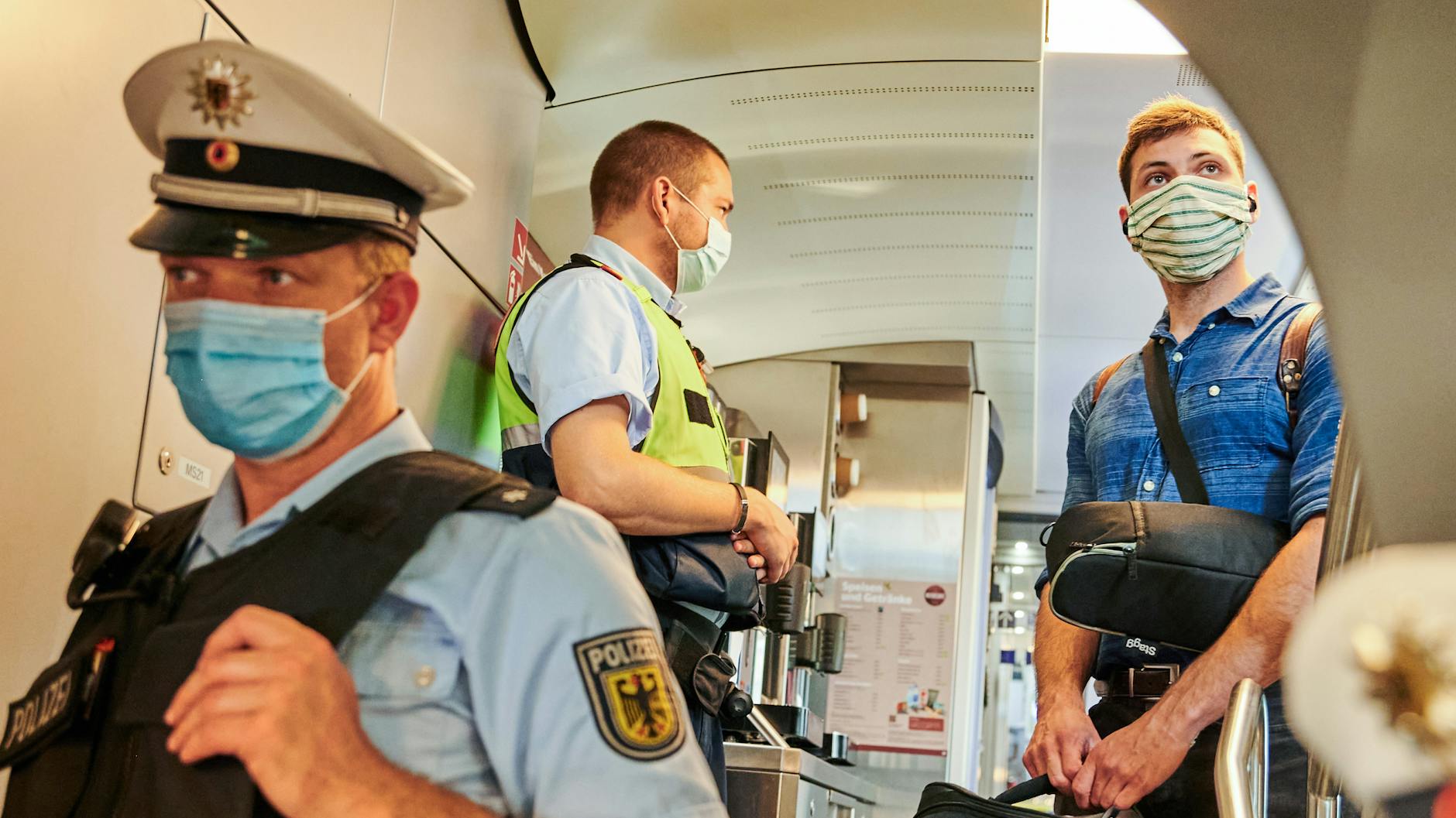 Beamte der Bundespolizei und Mitarbeiter der DB Sicherheit stehen in einem IC kurz vor dem Berliner Hauptbahnhof und kontrollieren, ob die coronabedingte Maskenpflicht eingehalten wird. 