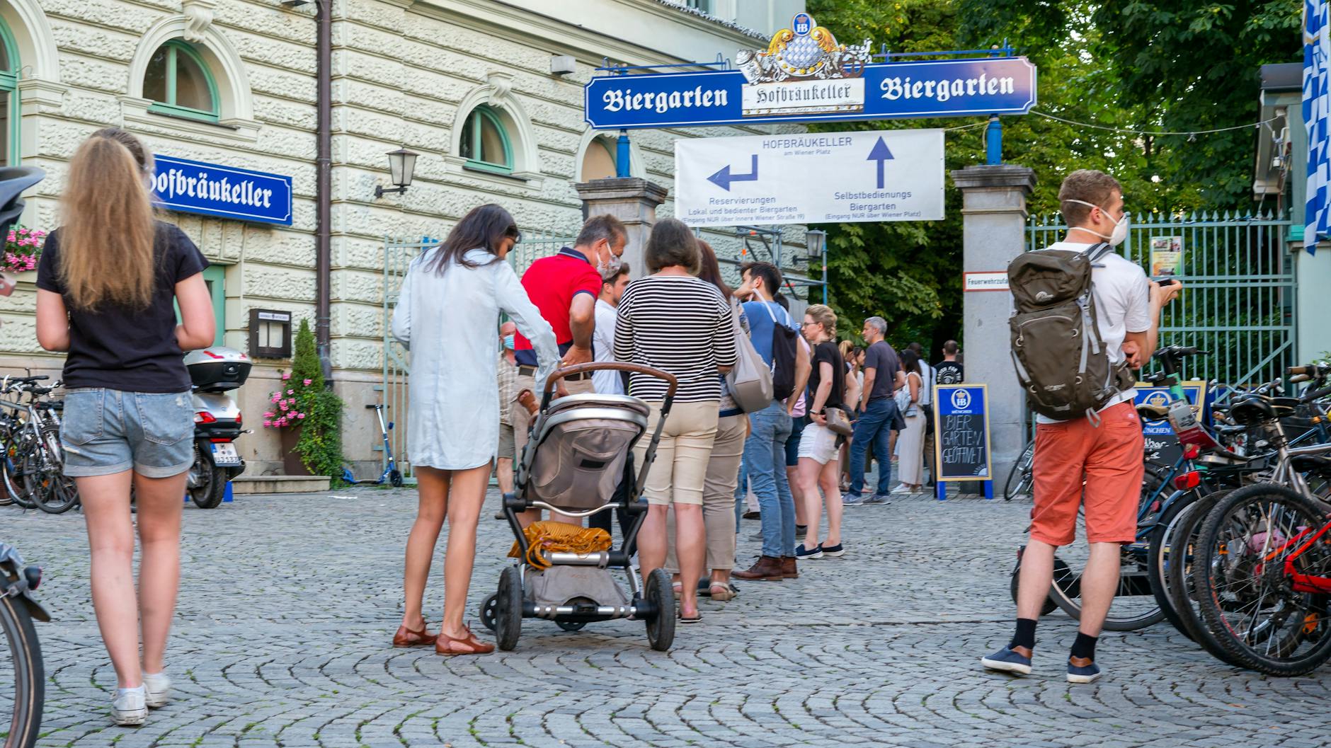 In München stehen Menschen an, um in den Biergarten zu kommen. Durch die Corona-Krise ist der Boom noch größer geworden.