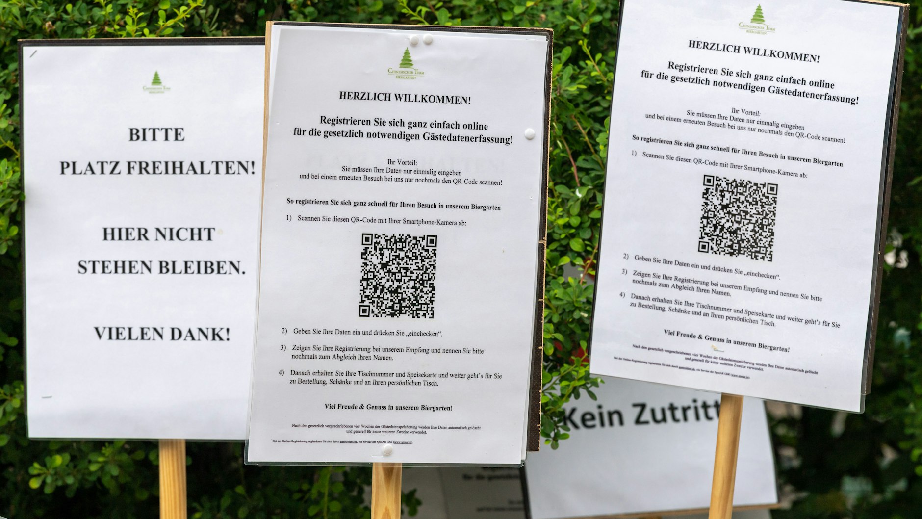 Hinweisschilder vor einem Biergarten in München weisen auf die coronabedingte Gästedatenerfassung hin.