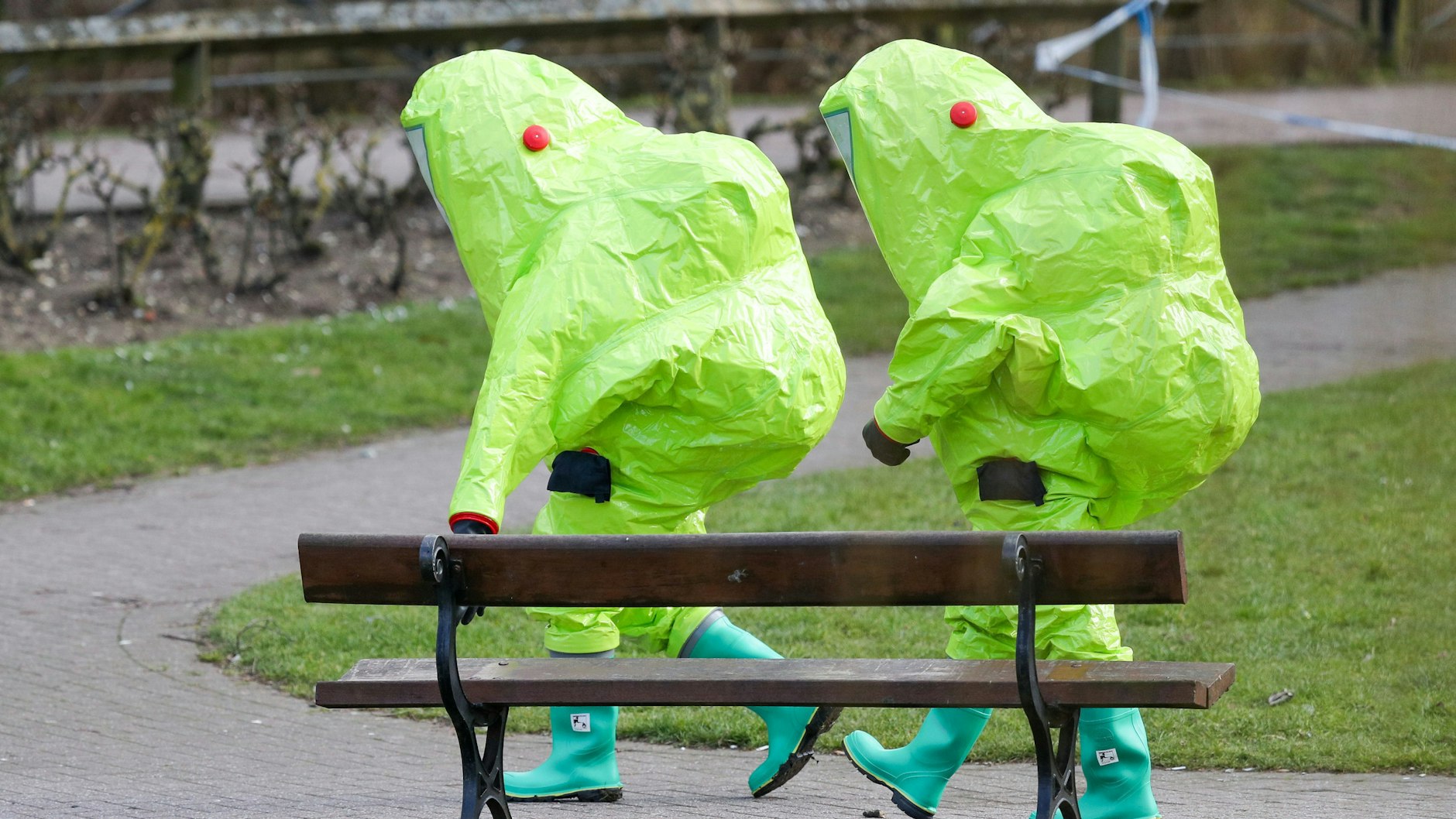 Im Vollschutz verlassen zwei Ermittler die Bank in Salisbury, auf der Sergej Skripal und seine Tochter gefunden worden waren – vergiftet mit Nowitschok.