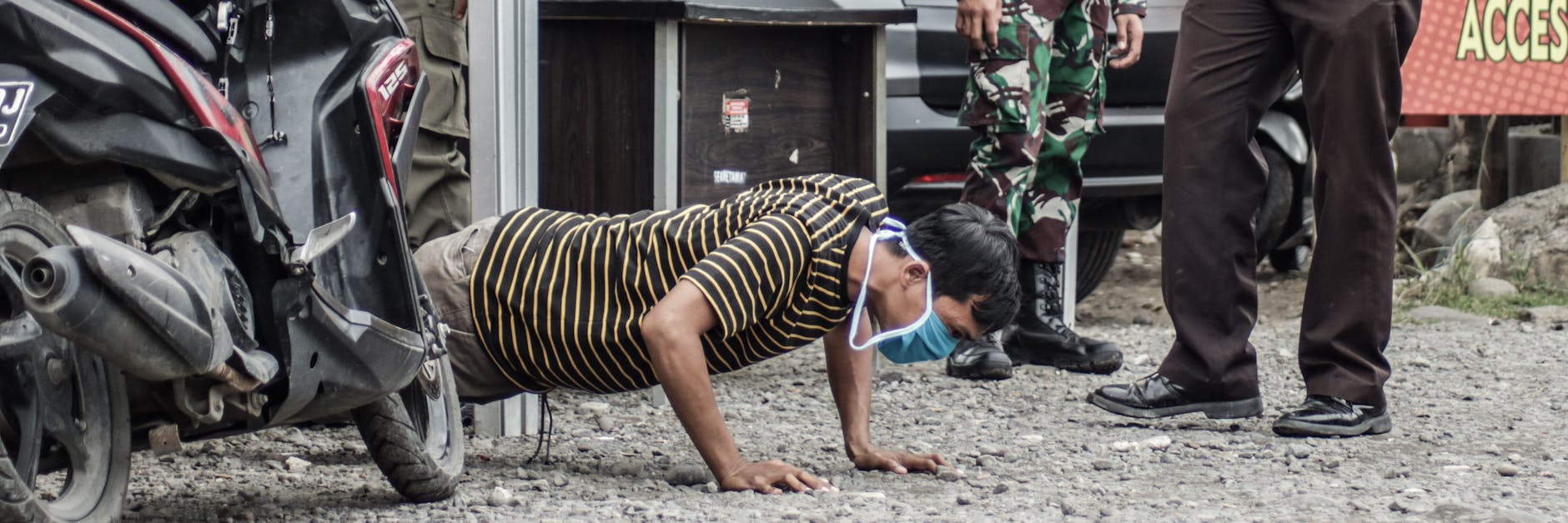 Weil er die Corona-Regeln missachtete, muss ein Mann in Indonesien Liegestütze machen.