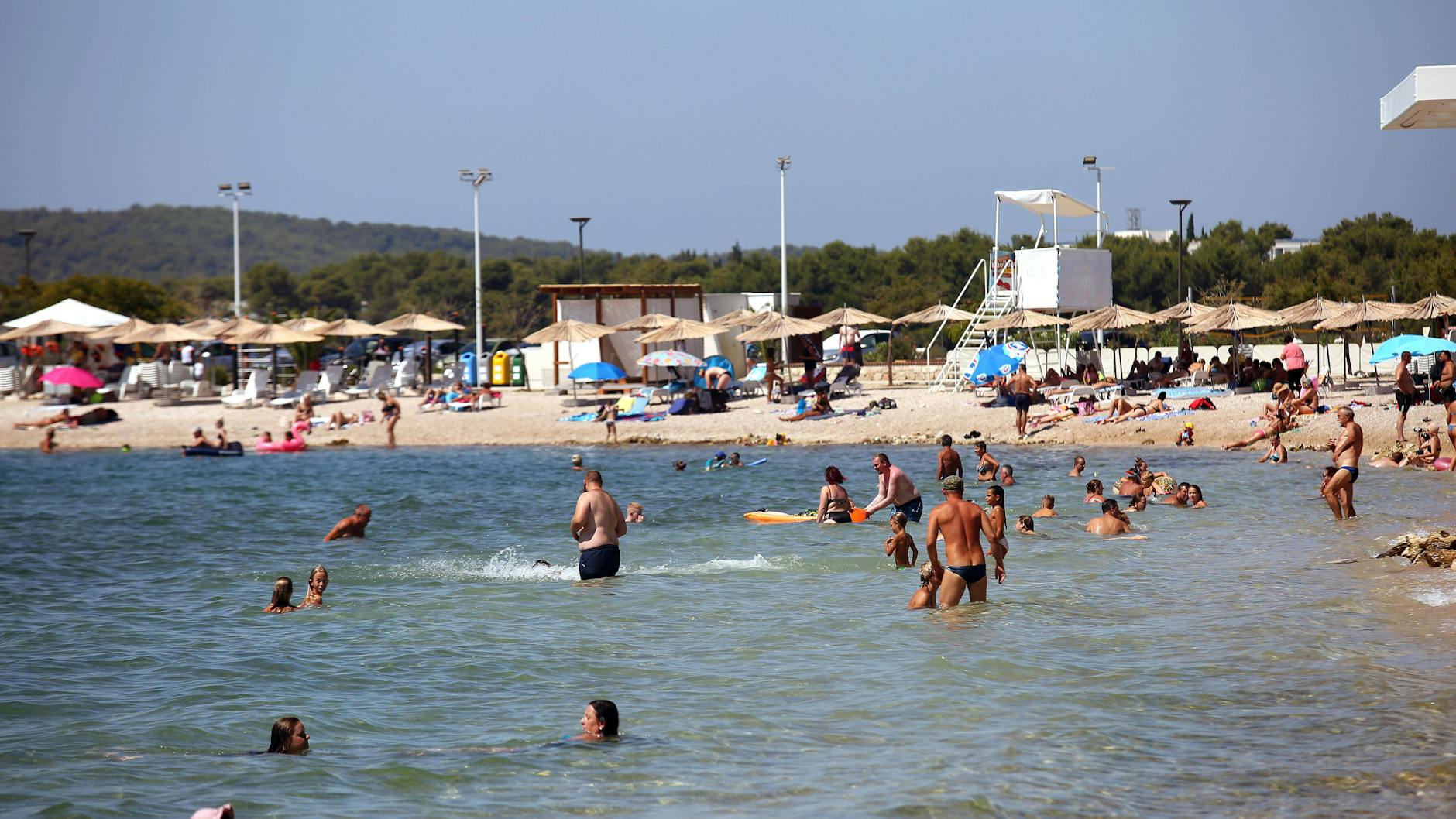 Touristen am Strand von Sibenik in Kroatien.