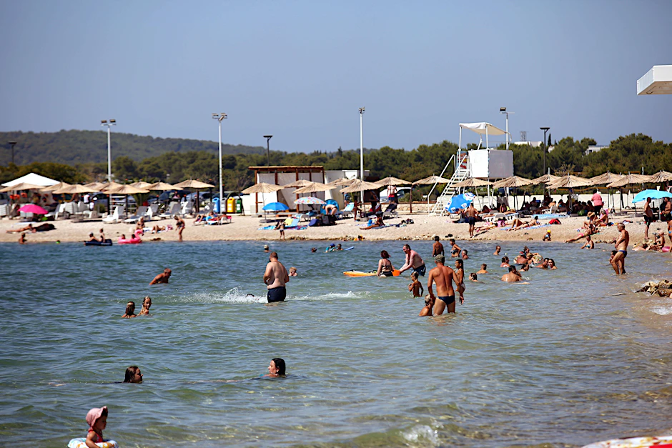 Touristen am Strand von Sibenik in Kroatien.