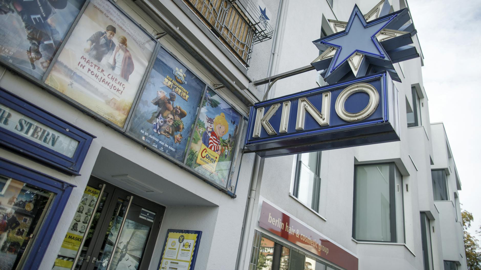 Film-Plakate und der namensgebende blaue Stern an der Fassade des Kinos. <br><br>
