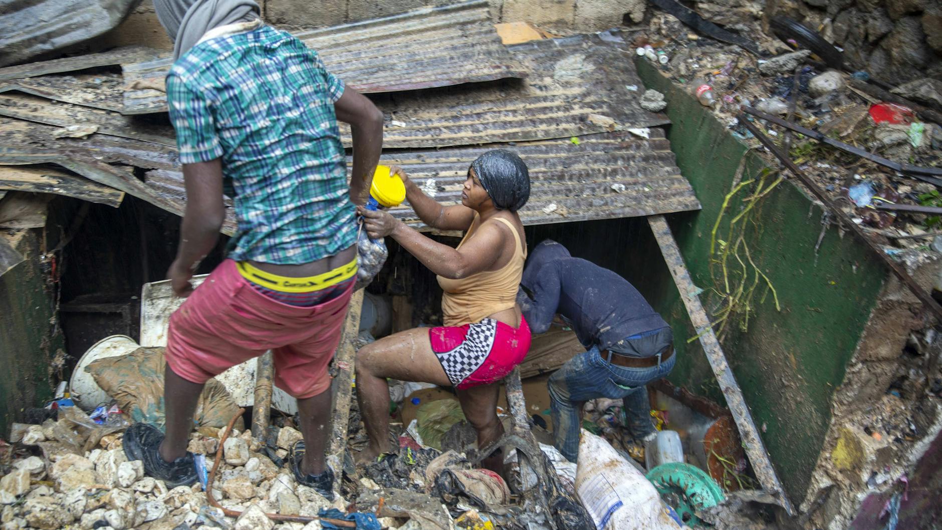 Diese Unterkunft in Port-au-Prince (Haiti) wurde komplett zerstört. Anwohner versuchen ihr Hab und Gut zu retten.