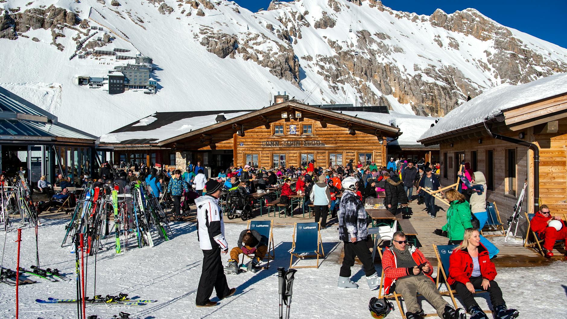 ARCHIV - 18.02.2019, Bayern, Garmisch-Partenkirchen: Skifahrer genießen vor einer Hütte das gute Wetter. Ungeachtet der Corona-Pandemie hofft die Wintersportbranche auf eine erfreuliche nächste Saison mit vielen Urlaubern. Skigebiete, Hersteller, Hotels und Sportgeschäfte im gesamten deutschsprachigen Alpenraum von Bayern bis Südtirol eint der Wunsch, dass der derzeitige Boom sommerlicher Freizeitsportarten an der frischen Luft sich auf den Winter übertragen könnte. Foto: Sina Schuldt/dpa +++ dpa-Bildfunk +++
