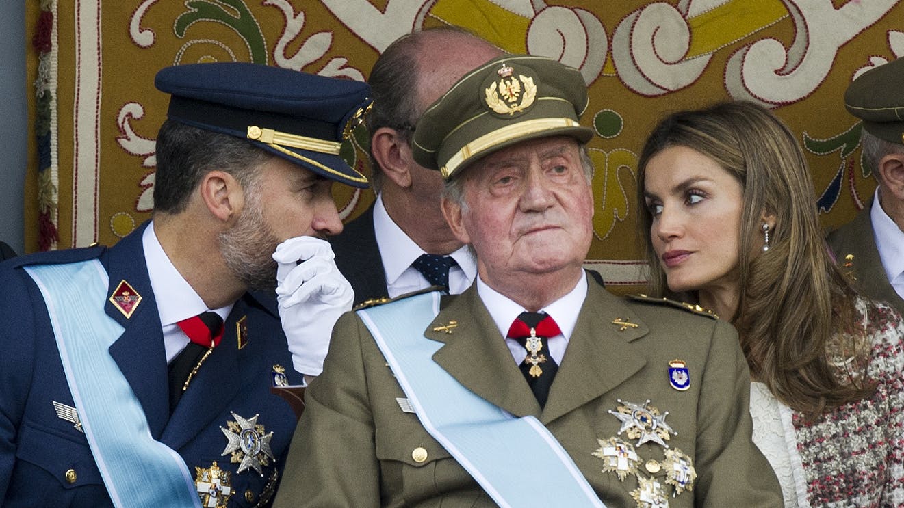 Felipe und seine Frau Letizia tuscheln miteinander, während Juan Carlos nach vorne schaut.