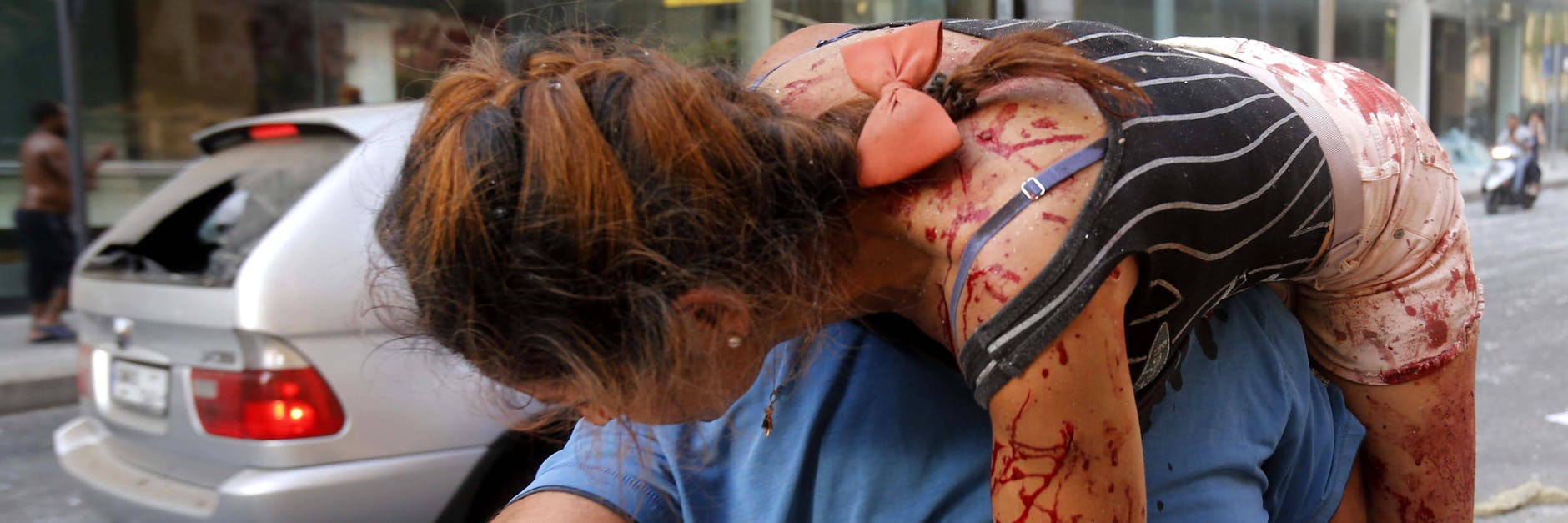 Ein Mann schleppt eine vermutlich durch Glassplitter verletzte Frau aus dem Katastrophengebiet.