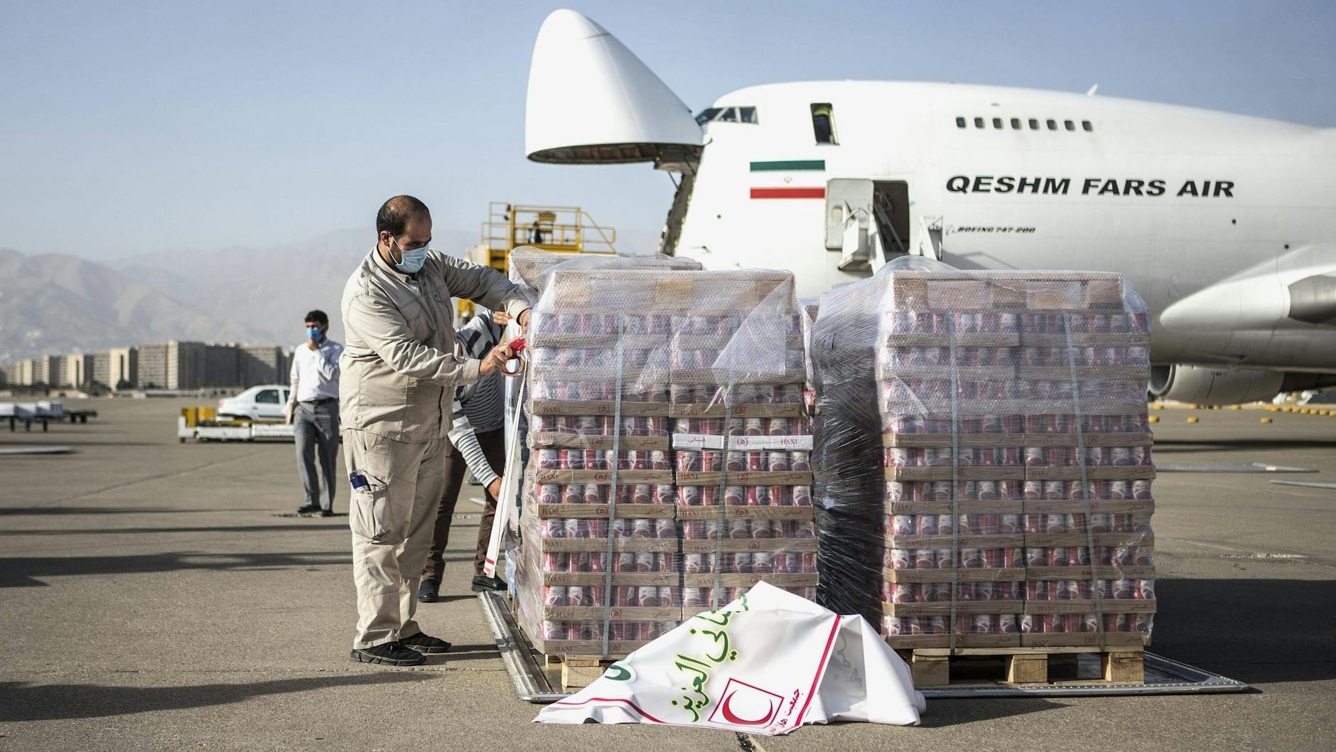 Arbeiter bereiten am Flughafen von Teheran (Iran) Lebensmittel und medizinische Ausrüstung für den Transport nach Beirut vor.