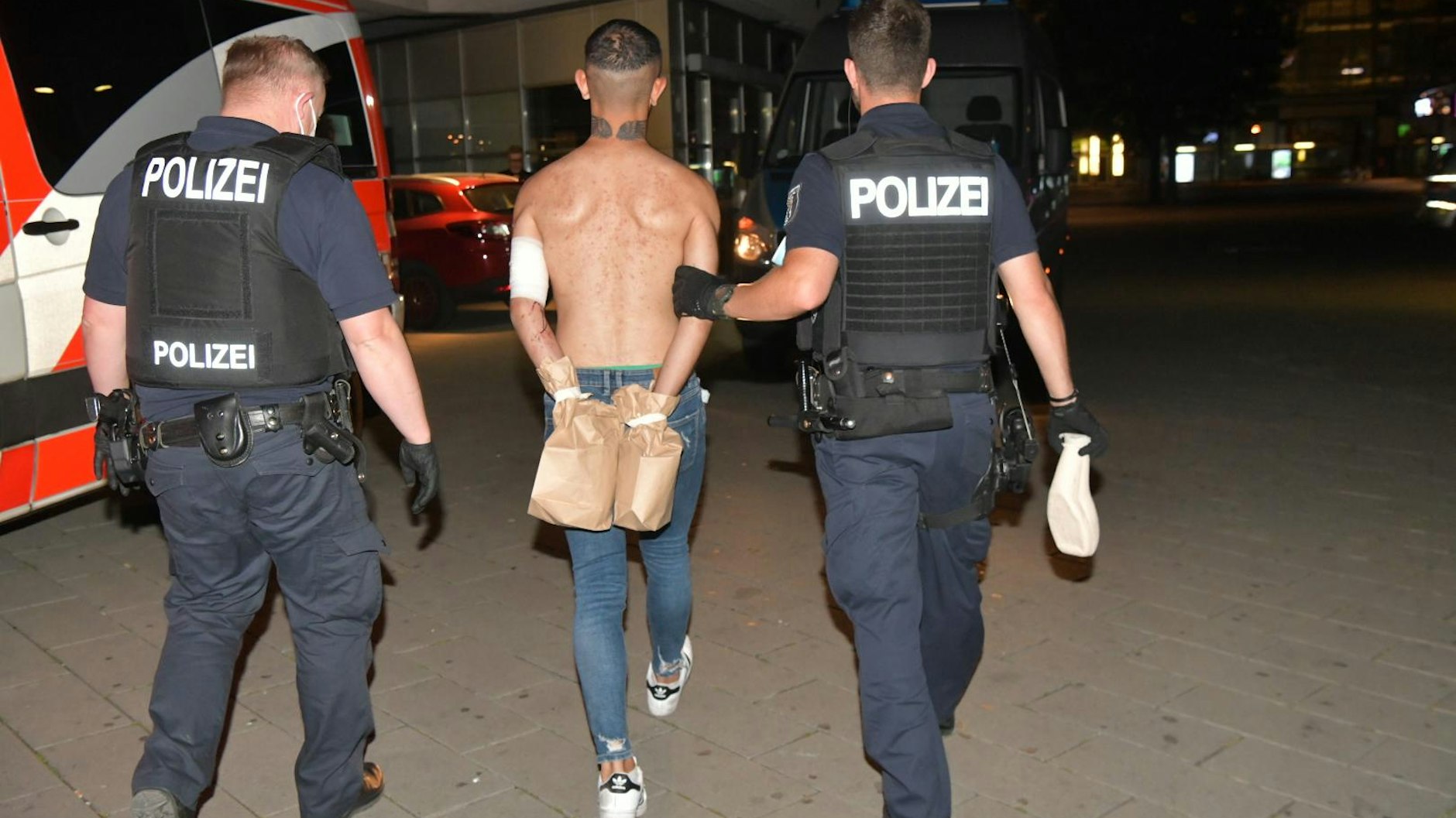 Die Polizei führt den 23-jährigen Tatverdächtigen ab.