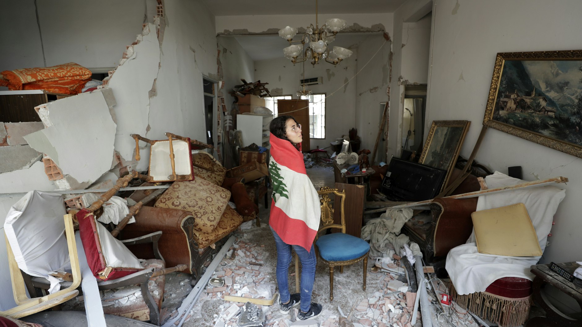 Die libanesische Flagge um die Schultern gelegt, begutachtet Farah Mahmoud die Schäden in der verwüsteten Wohnung ihrer Eltern.
