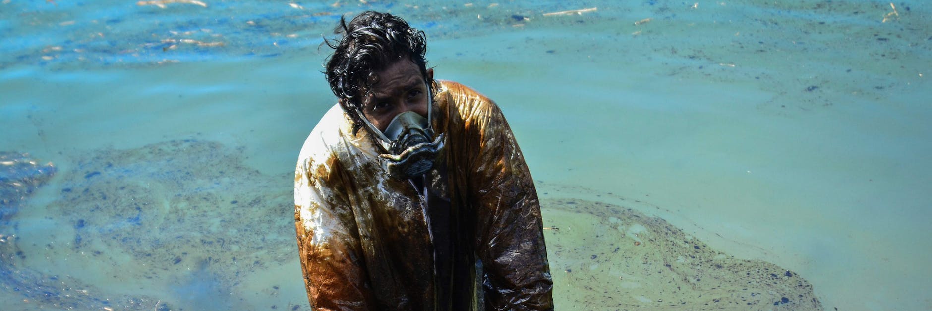 Ein Mann versucht, das ausgelaufene Öl an der Küste Mauritius aufzufangen.