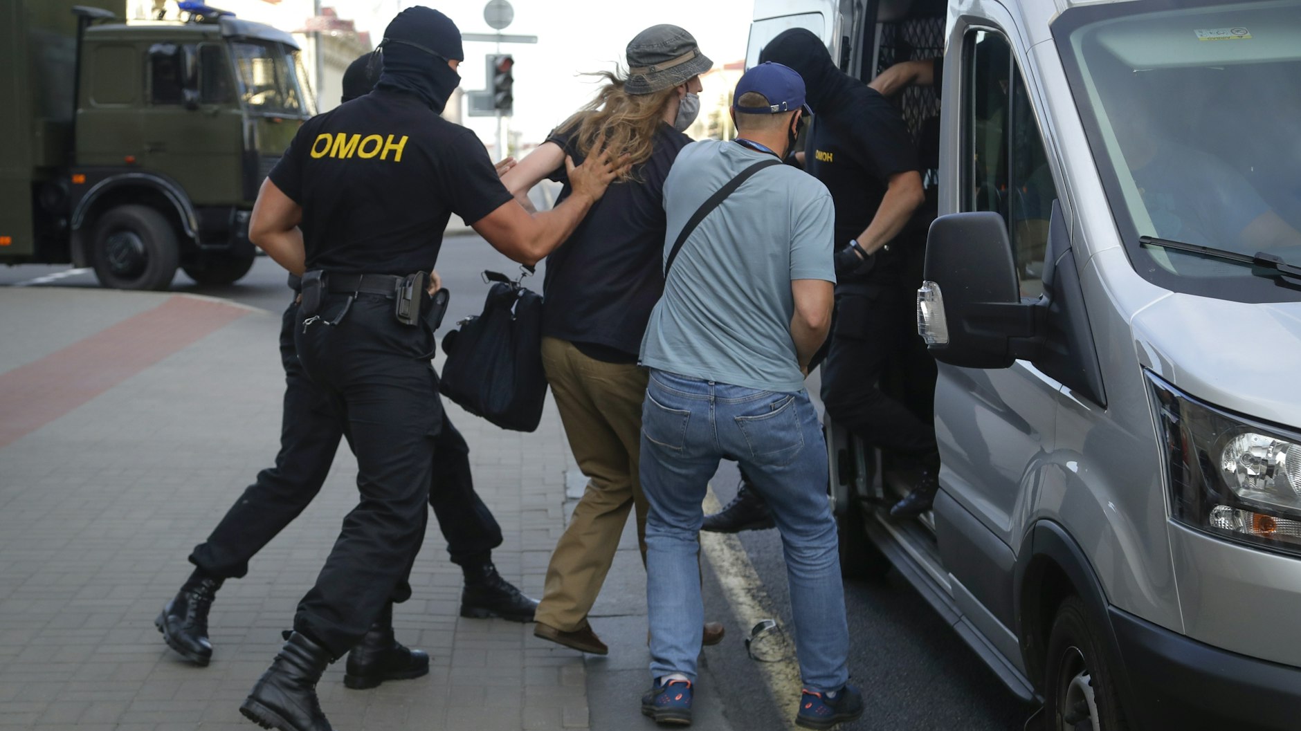 Polizisten verhaften am Vorabend der Wahl einen Demonstranten, als Hunderte von Oppositionsanhängern durch das Zentrum der Hauptstadt fuhren, Fahnen schwenkten und Siegeszeichen mit geballter Faust aus den Fenstern der Fahrzeuge schwenkten. 