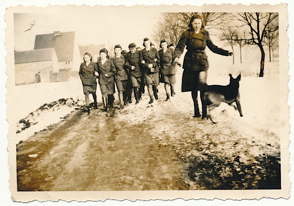 Das nach 1940 entstandene Privatfoto zeigt eine Gruppe von Aufseherinnen aus dem Frauen-Konzentrationslager Ravensbrück mit Schäferhund in Dienstuniform.