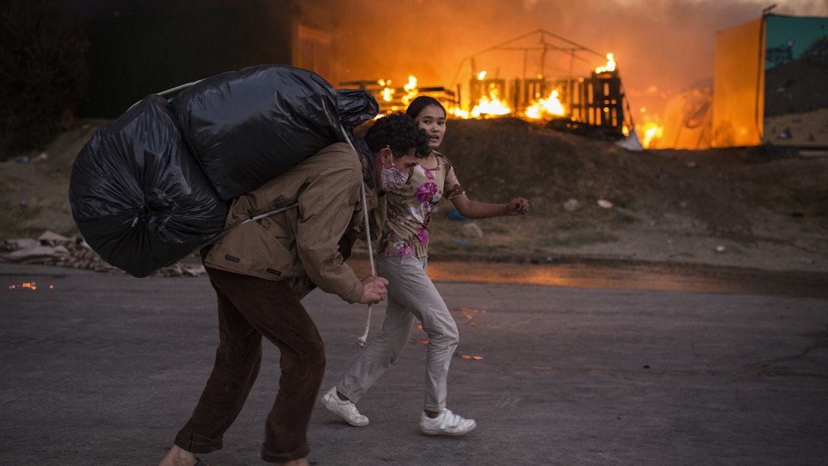 Moria: Migranten fliehen vor neu ausgebrochenen  Feuern mit ihren Habseligkeiten aus dem Flüchtlingslager Moria.
