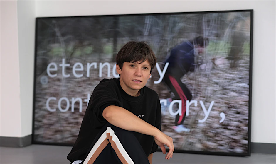 Marina Naprushkina against a backdrop of her video work Future for everyone (2020), part of her new exhibition <em>Keine Zeit für Kunst</em>