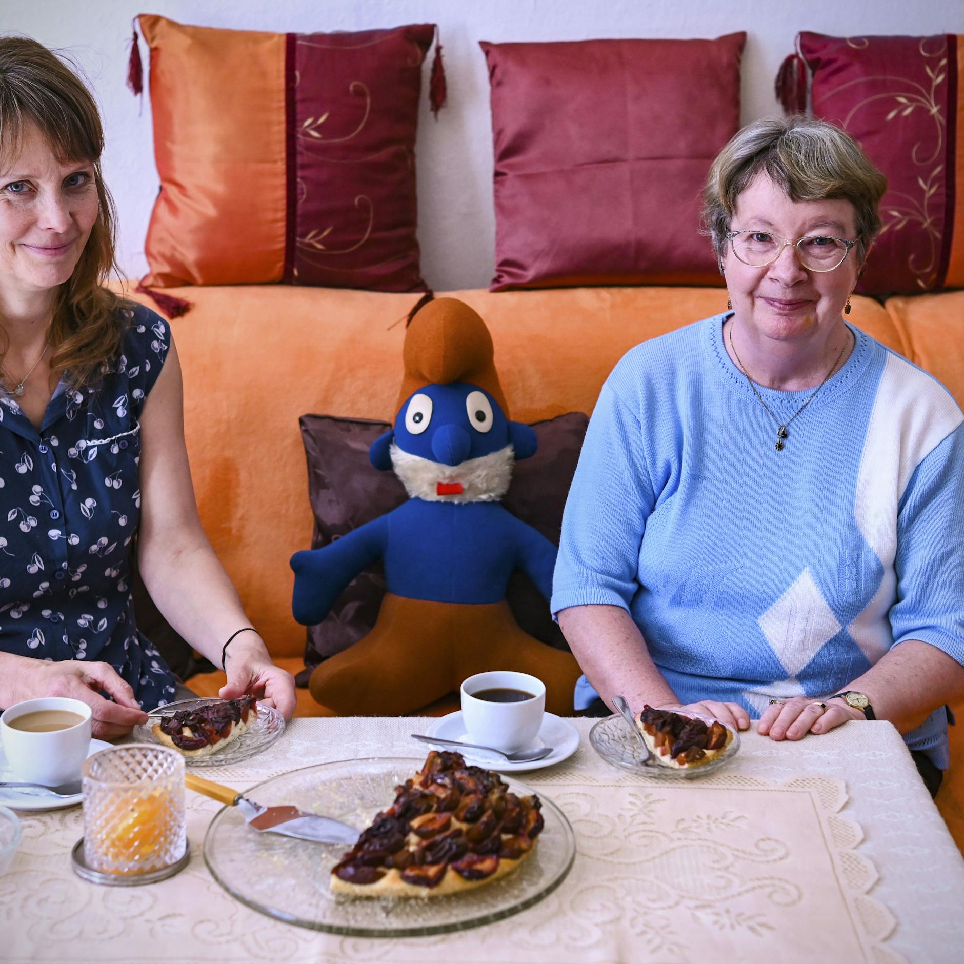 Die zwei Frauen auf dem Sofa in der Wohnung von Monika Krannig, zwischen ihnen der Schlumpf aus tiefsten DDR-Zeiten. 