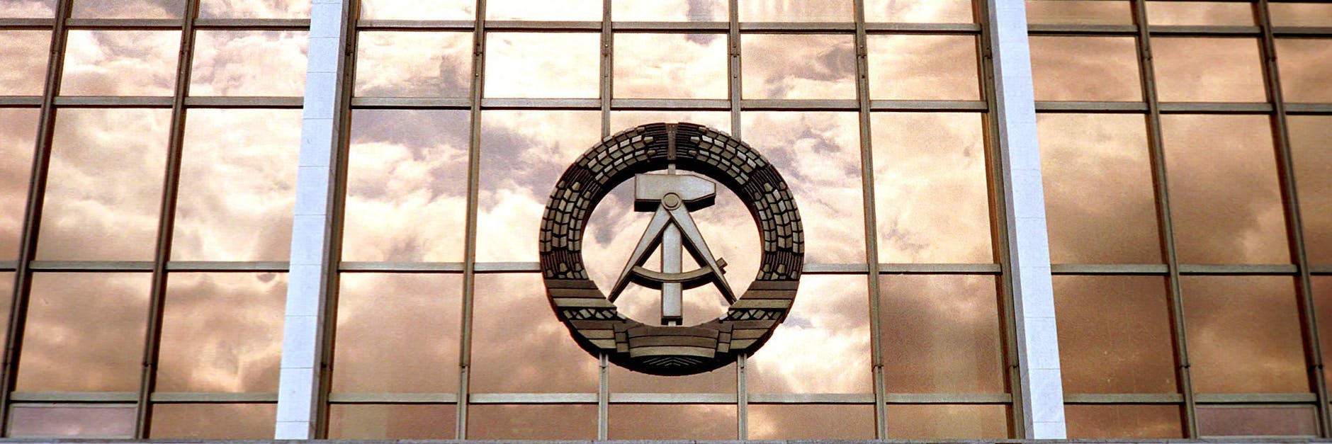 Das Staatswappen der DDR ist wie der Palast der Republik schon längst verschwunden. Dennoch existiert der Arbeiter-und -Bauern-Staat in Berlin weiter.