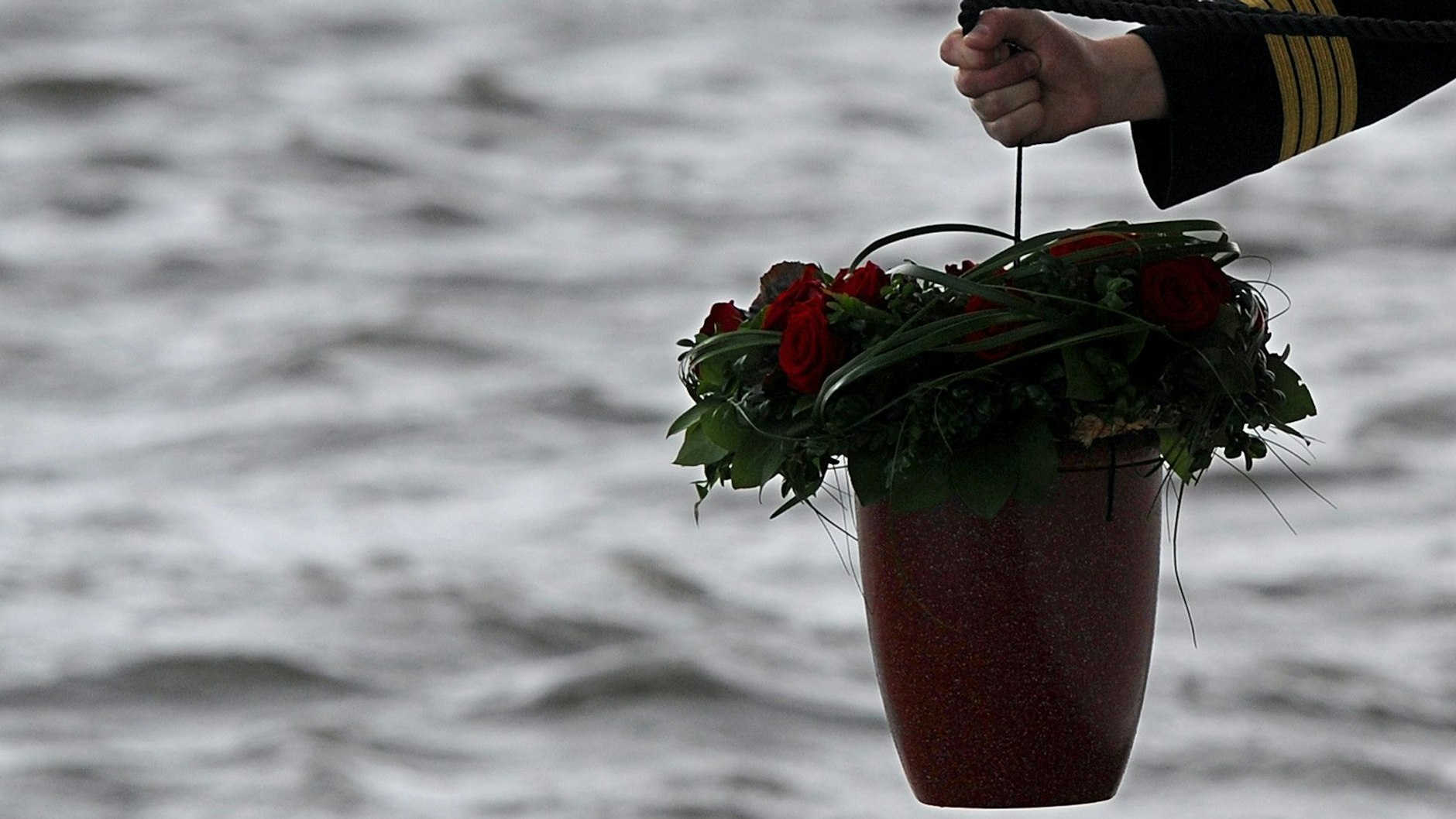 Ein Seebestatter lässt in Höhe der ostfriesischen Insel Wangerooge eine Urne aus Muschelkalk in die Nordsee hinab.