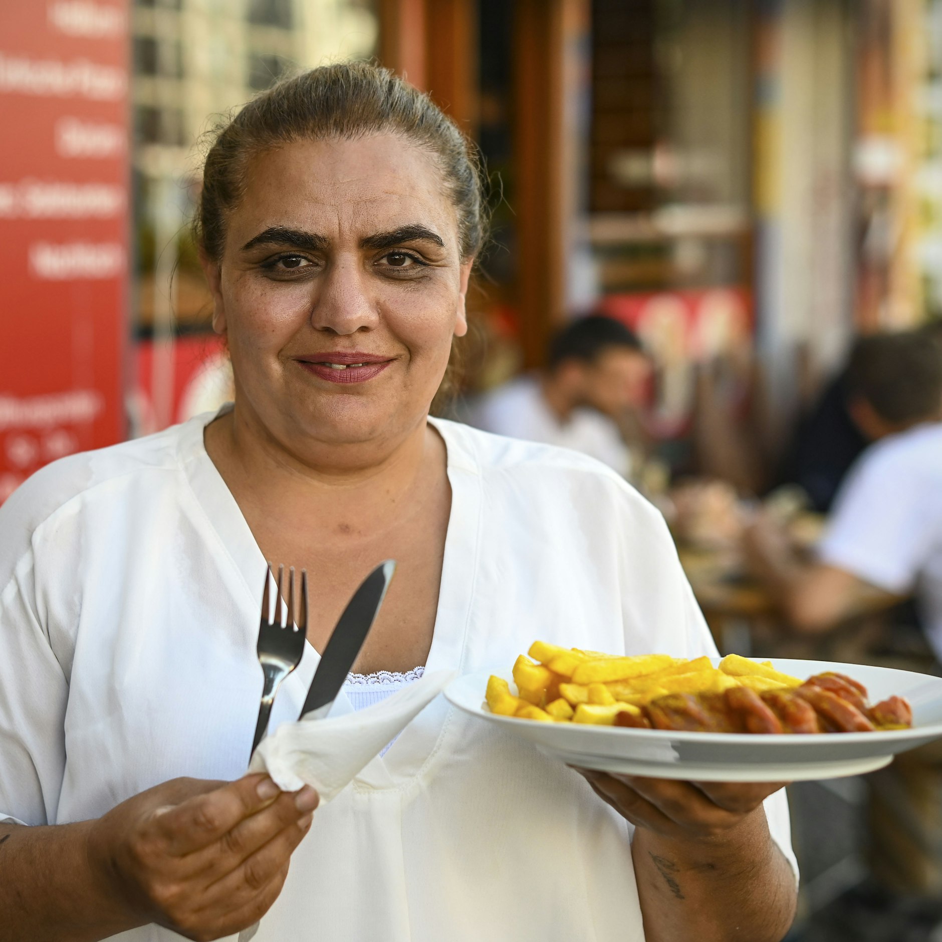 Dilber Dogan serviert Currywurst und Pommes.&nbsp;