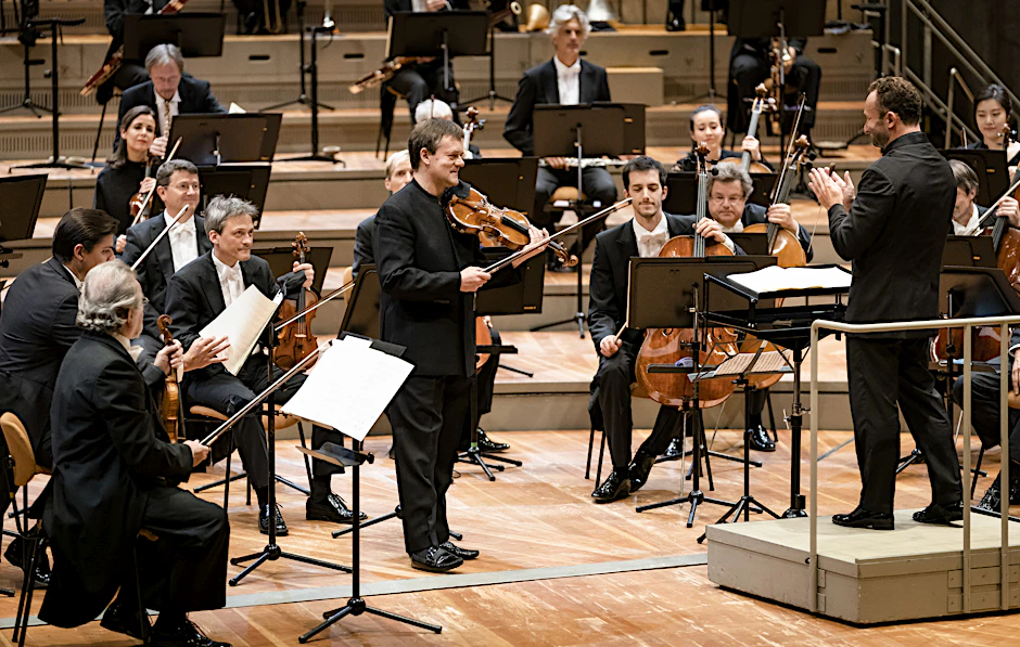 Die Berliner Philharmoniker, mit ihrem Dirigenten Kirill Petrenko (rechts) und dem Solisten Frank Peter Zimmermann (stehend).