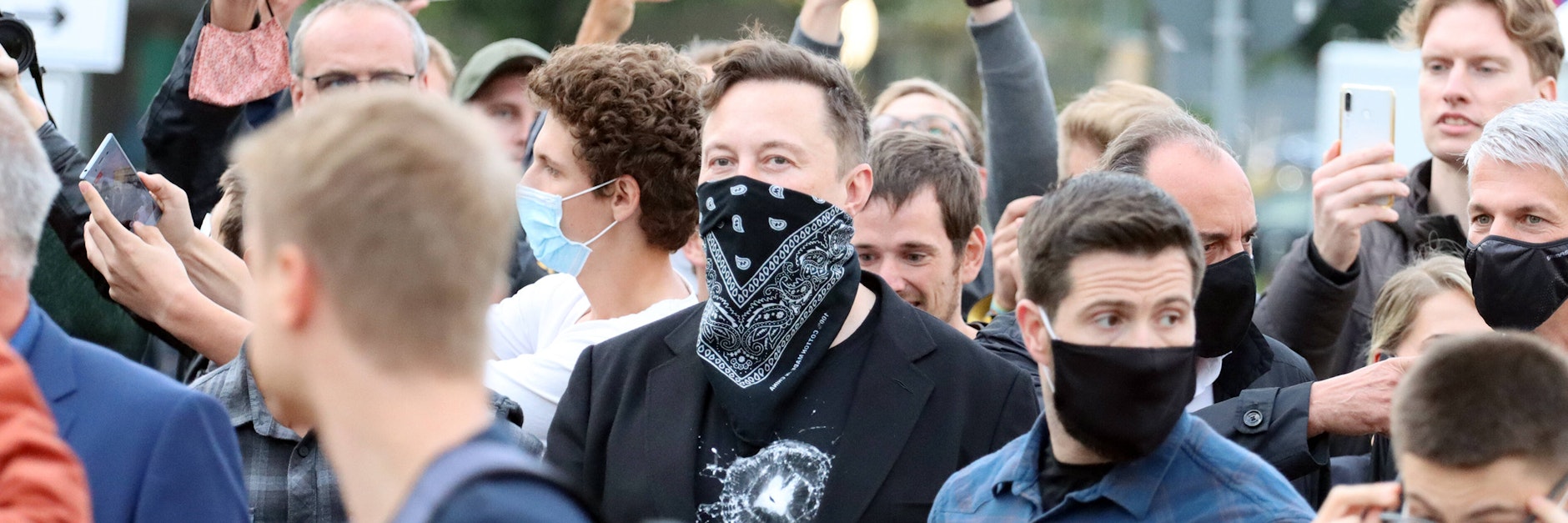 Trubel in Tübingen: Elon Musk, gelernter Maschinenbauingenieur, beim Besuch des Biotech-Unternehmens Curevac, das an einem Corona-Impfstoff arbeitet und Maschinen einer Tesla-Tochterfirma nutzen will. Er trägt ein Tuch statt einer Maske vor dem Gesicht.