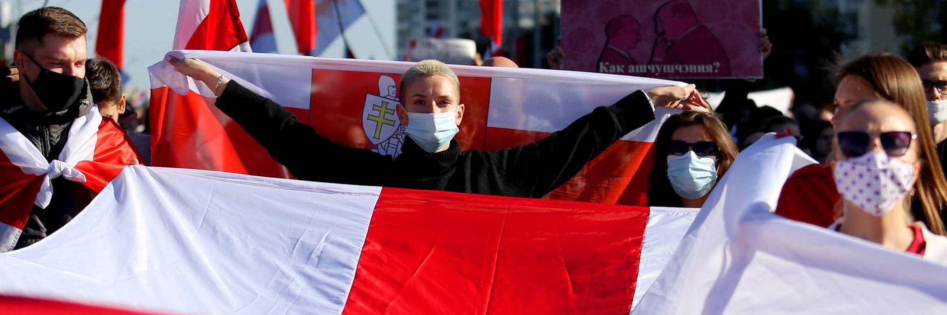 Viele Demonstranten waren eingehüllt in riesige rot-weiße frühere Nationalflaggen von Belarus.