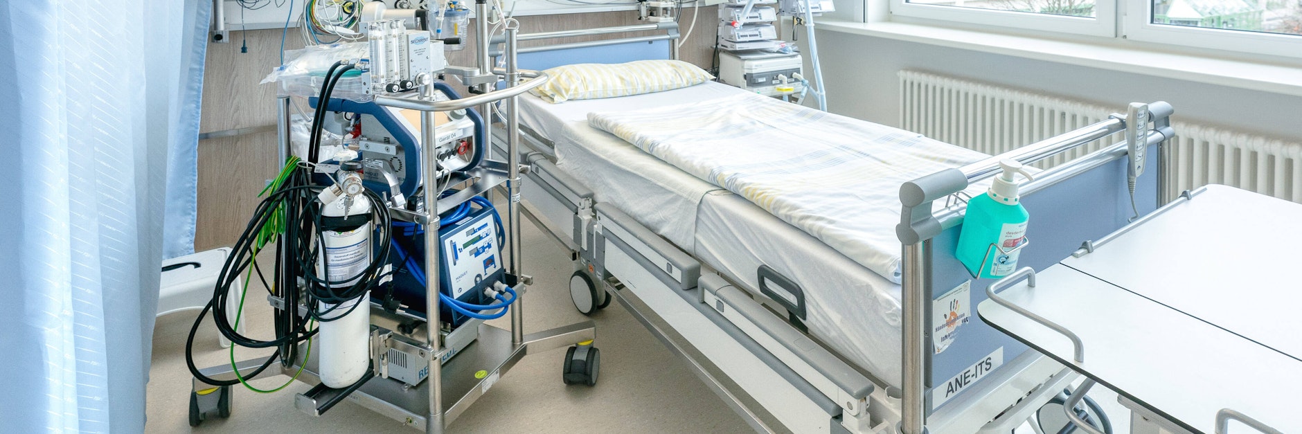 Ein Intensivbett in einer Intensivstation der Uniklinik Dresden. Links neben dem Bett steht eine Herz-Lungen-Maschine.