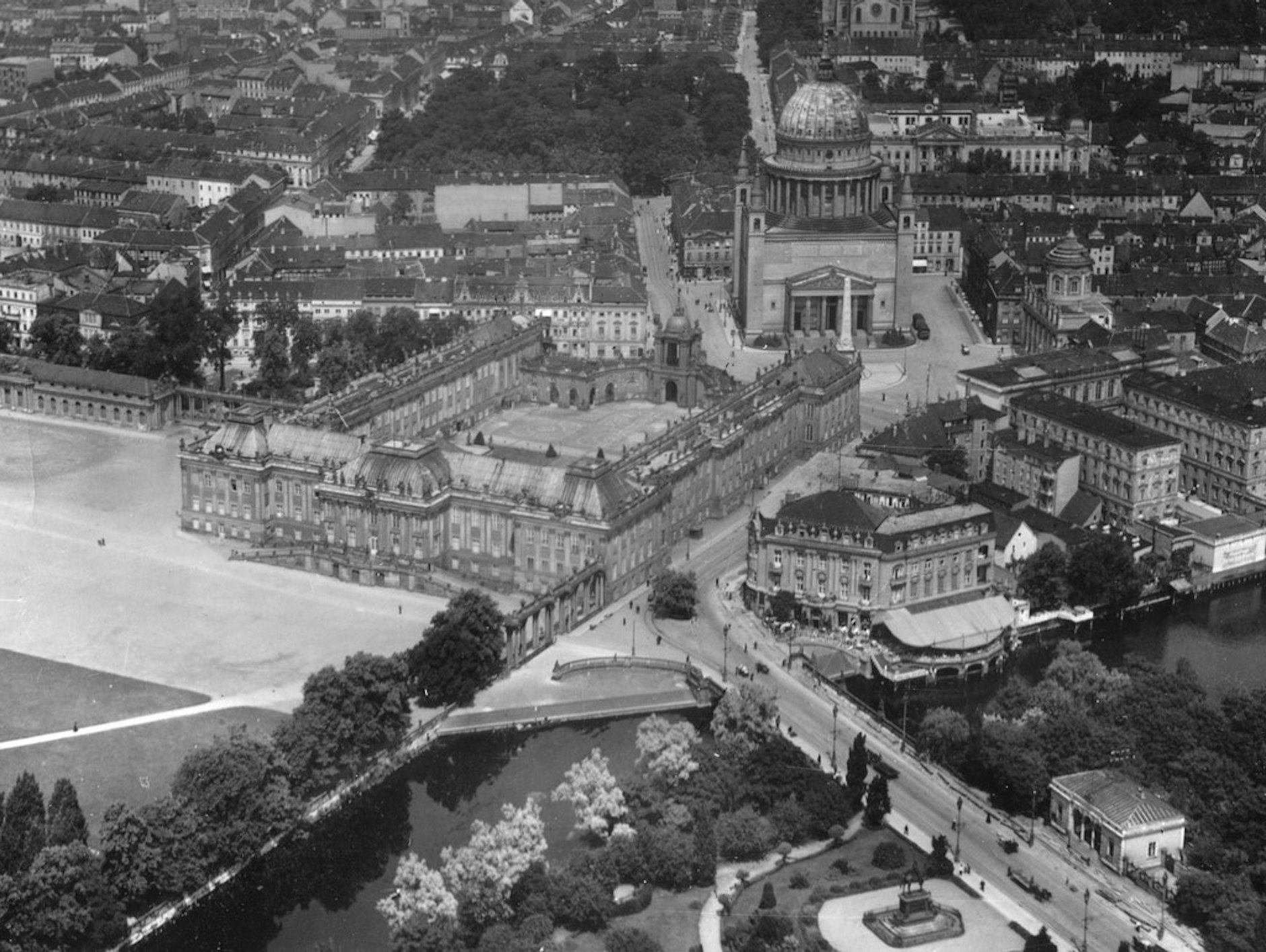 Das Stadtschloss Potsdam mit Paradeplatz und Lustgarten, dahinter die Nikolaikirche mit der markanten Kuppel. Rechts unten führt die Lange Brücke auf die „Bittschriftenlinde“ zu, rechts daneben das Palast-Hotel und der Palast Barberini.