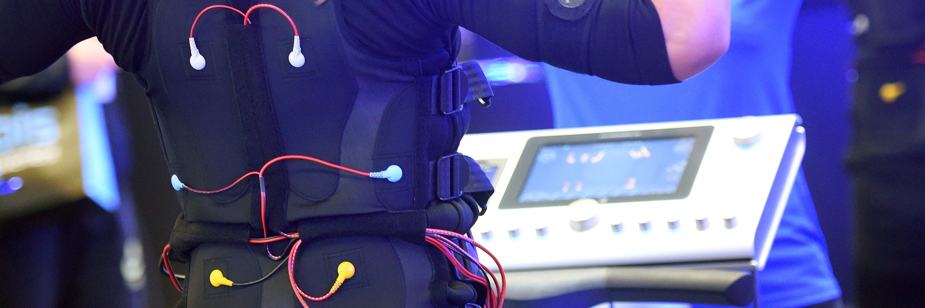 Beim EMS-Training tragen Sportlerinnen und Sportler eine verkabelte Weste und Manschetten, über die elektronische Impulse an den Körper weitergeleitet werden.