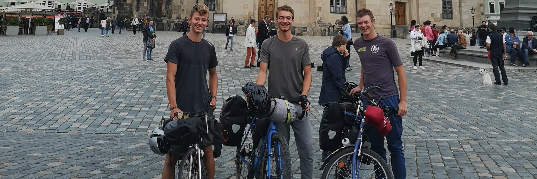 Die drei Kölner Abiturienten Anton, Lovis und Till stehen mit ihren Fahrrädern vor der Dresdener Frauenkirche.