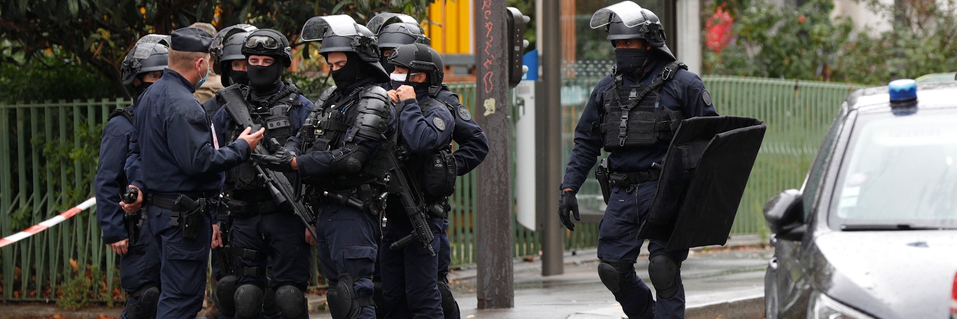 Schwer bewaffnete Polizisten stehen am Tatort.