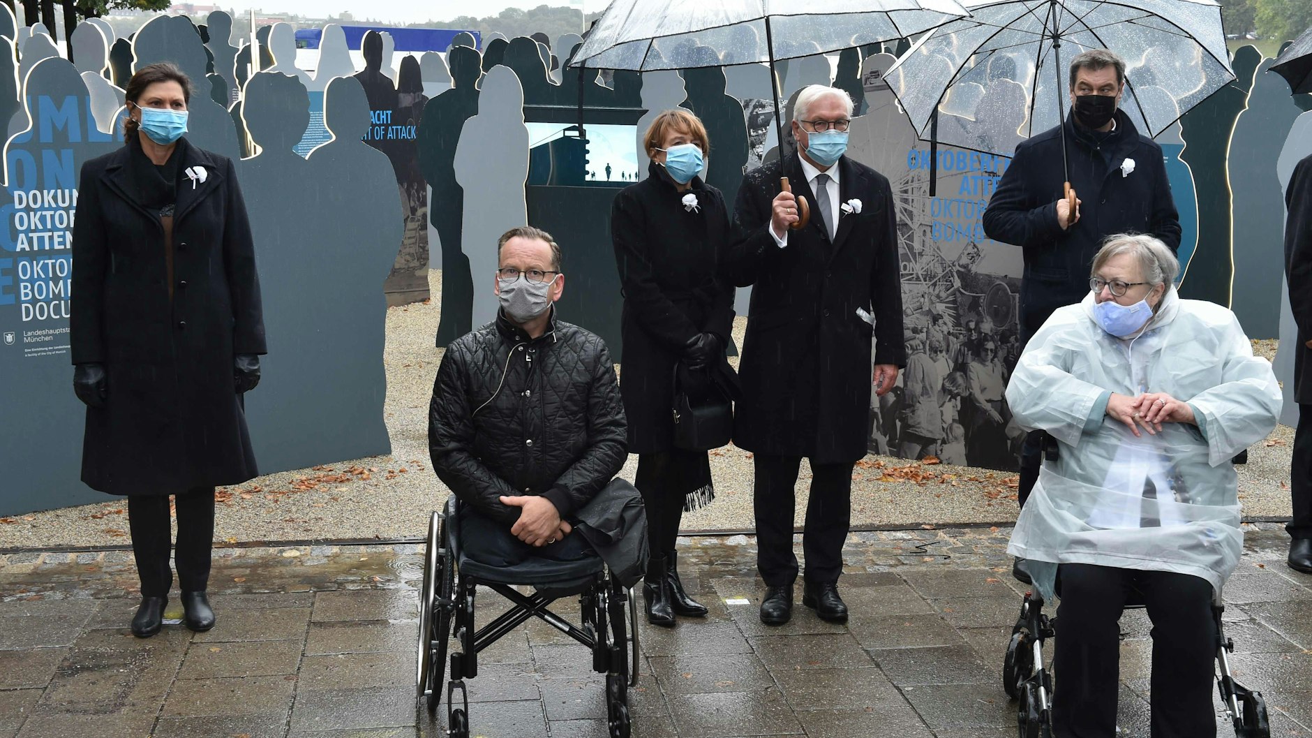 Dimitrios Lagkadinos und Renate Martinez (vorn) haben das Attentat überlebt. Lagkadinos verlor dabei beide Beine. Hinten: Bayerns Landtagspräsidentin Ilse Aigner (CSU), Bundespräsident Frank-Walter Steinmeier und seine Frau Elke Büdenbender und Bayerns Regierungschef Markus Söder (v.l.).