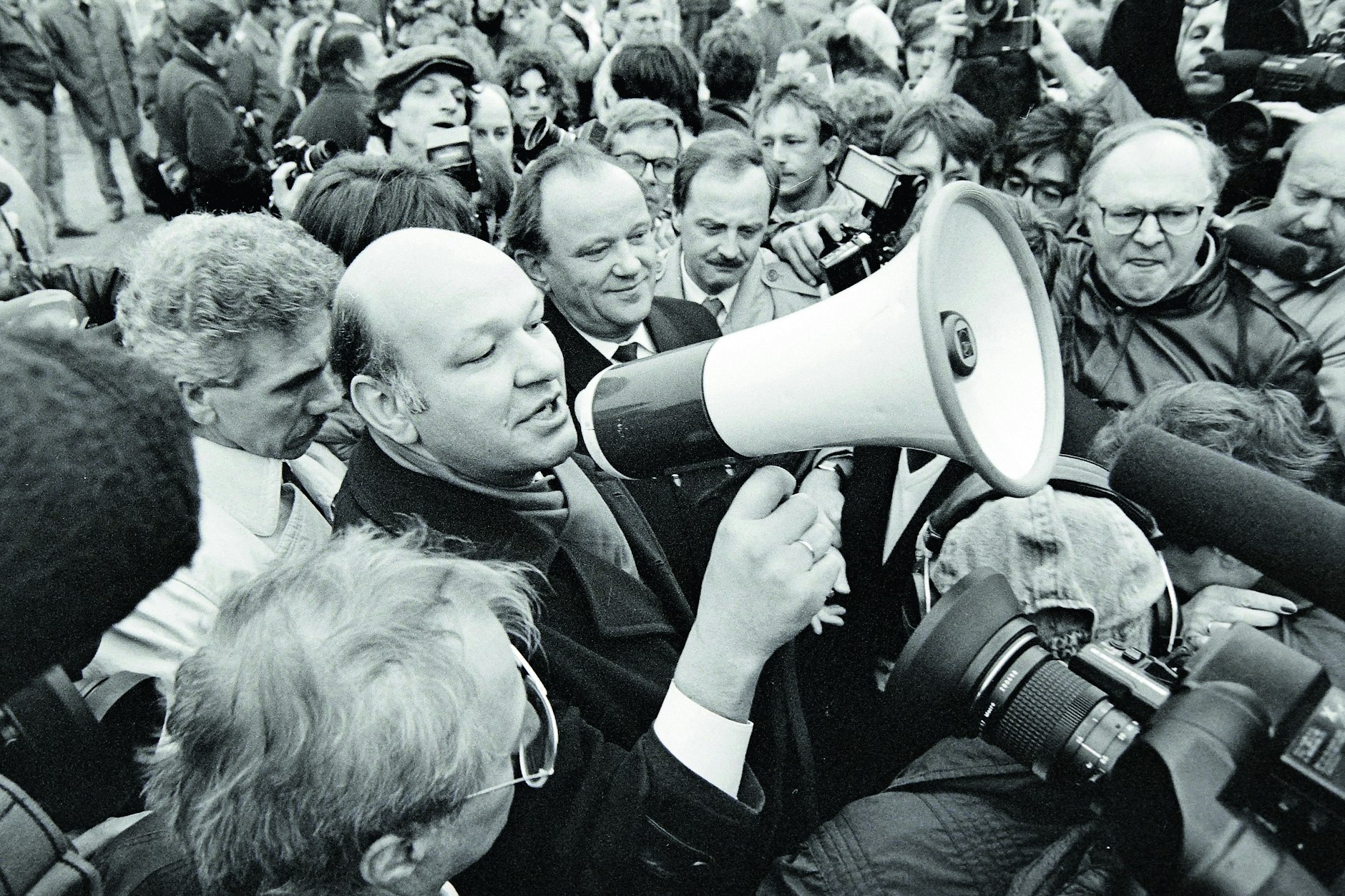 Aufbruchstimmung. Walter Momper, Regierender Bürgermeister von West-Berlin, hält am 12. November 1989 auf dem Potsdamer Platz eine Rede. Anlass ist die Öffnung eines neuen Grenzübergangs. Der Mann links neben ihm Erhard Krack, Oberbürgermeister von Ost-Berlin.