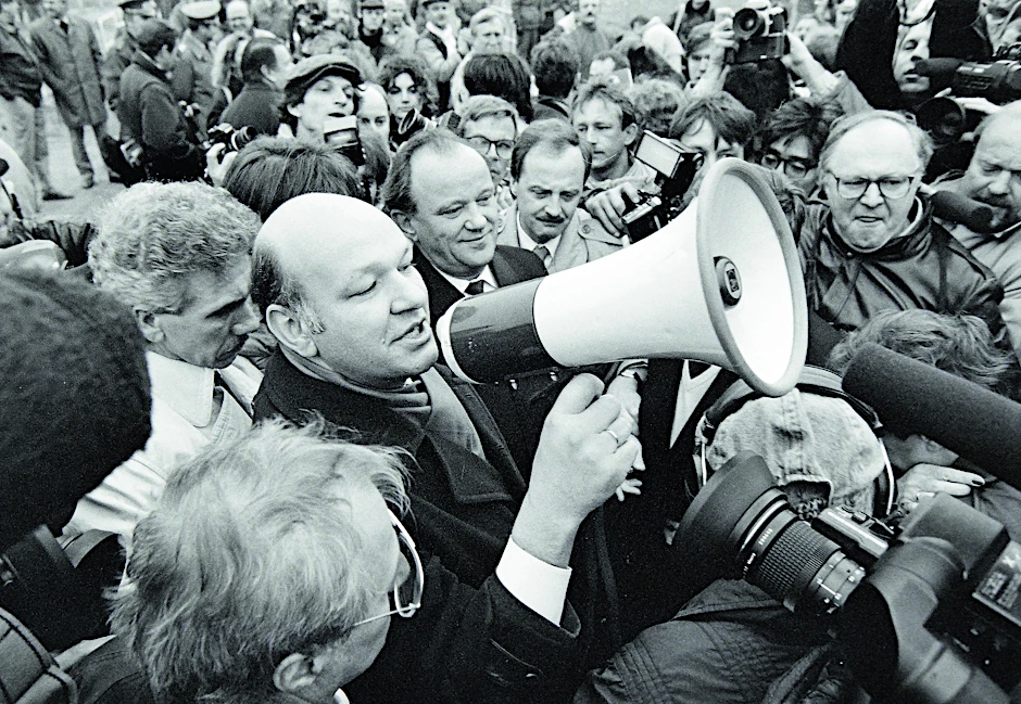 Aufbruchstimmung. Walter Momper, Regierender Bürgermeister von West-Berlin, hält am 12. November 1989 auf dem Potsdamer Platz eine Rede. Anlass ist die Öffnung eines neuen Grenzübergangs. Der Mann links neben ihm Erhard Krack, Oberbürgermeister von Ost-Berlin.