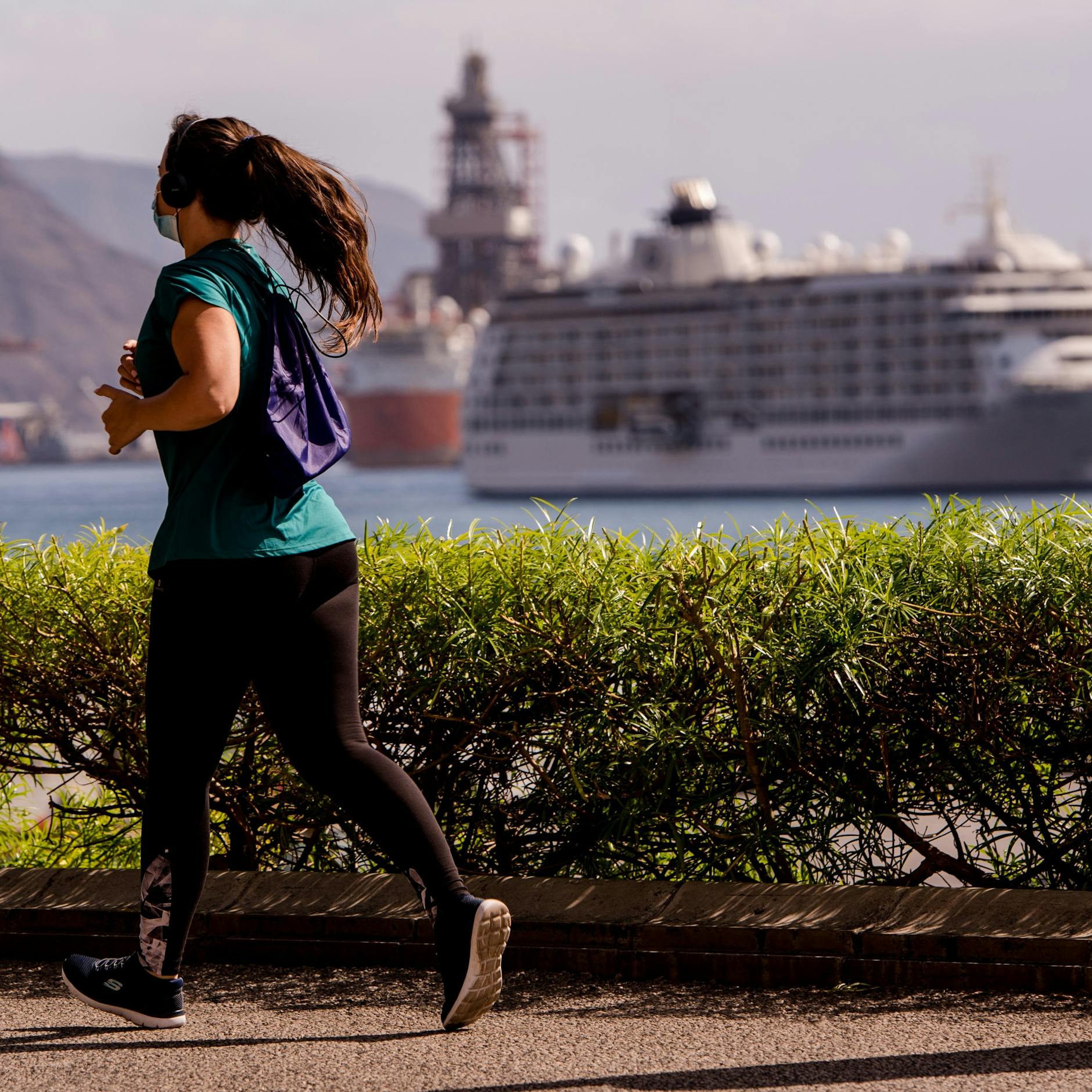 Eine Frau joggt durch den Hafen von Santa Cruz auf Teneriffa.