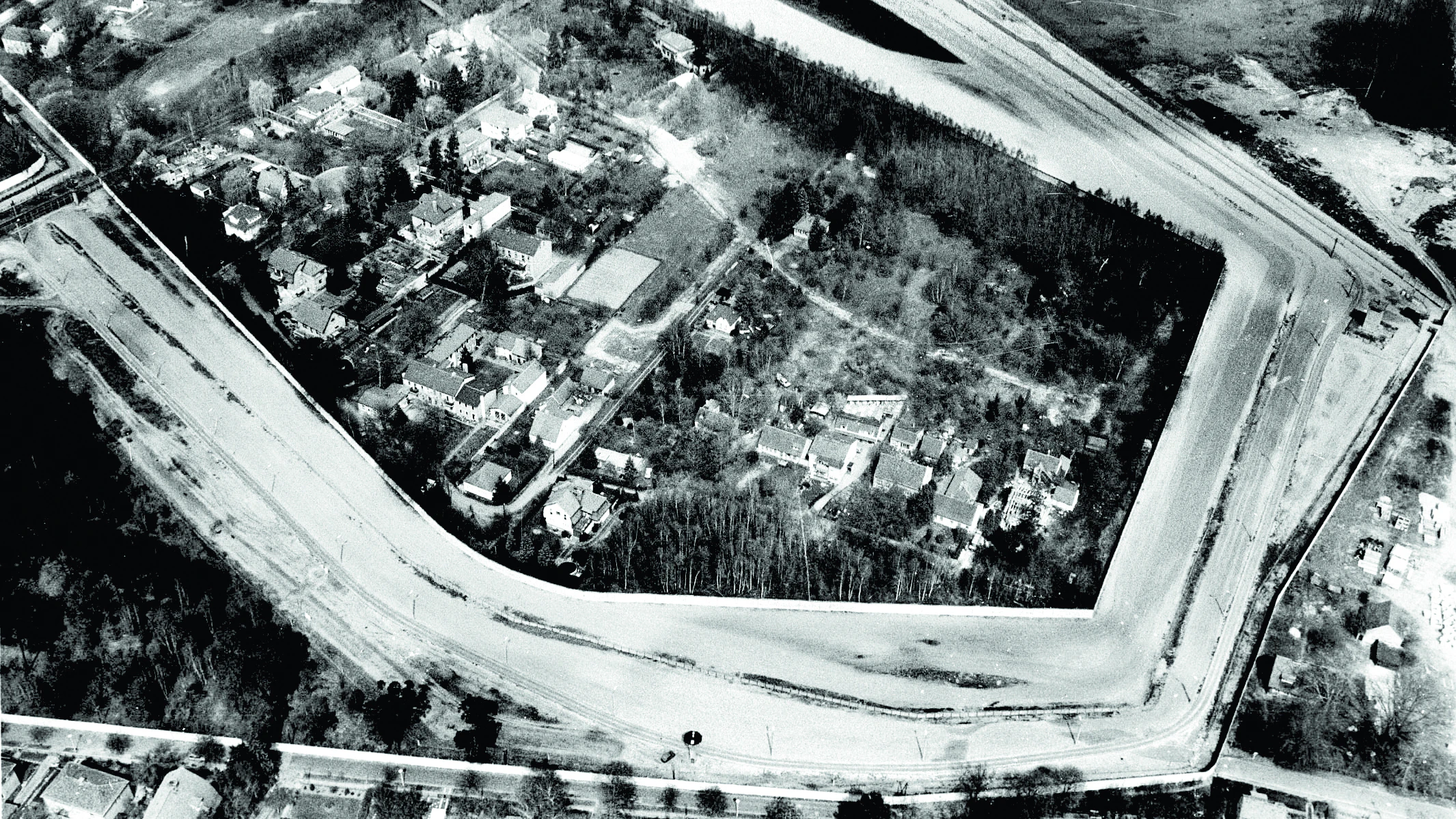 This aerial shot shows Steinstücken surrounded by the Wall and death strip in 1986.&nbsp;From 1961 to 1972, the US military could only reach the exclave by air and built a helipad.