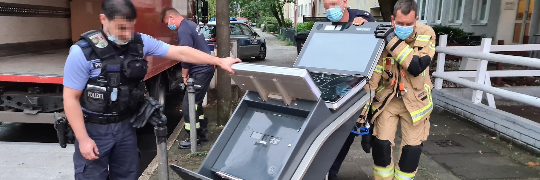 Polizisten und ein Feuerwehrmann hieven am Sterndamm einen der illegalen Spielautomaten auf einen Lastwagen.