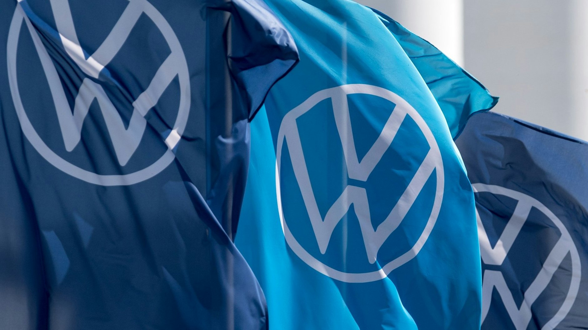 Fahnen mit dem VW-Logo wehen im Fahrzeugwerk von Volkswagen in Zwickau.
