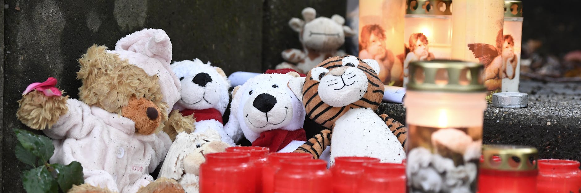 Teddybären und Kerzen haben Mitmenschen vor dem Haus niedergelegt, in dem die Polizei fünf Kindern tot gefunden hat. 